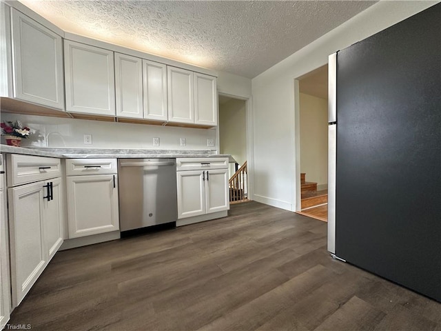 kitchen with appliances with stainless steel finishes, dark hardwood / wood-style flooring, a textured ceiling, and white cabinetry