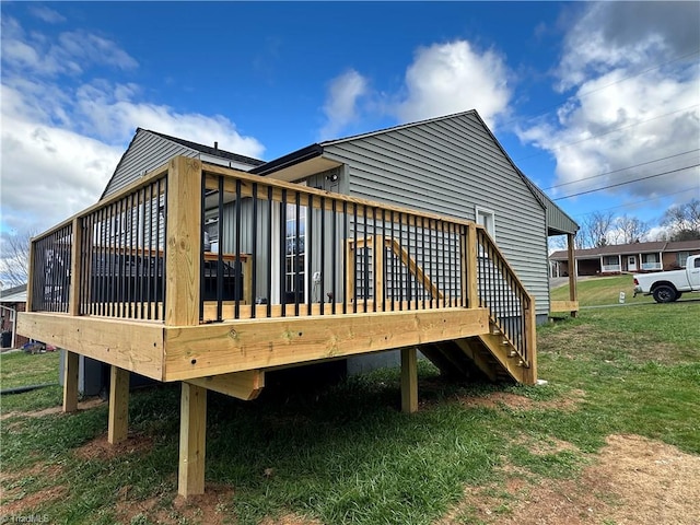 rear view of house with a lawn and a wooden deck