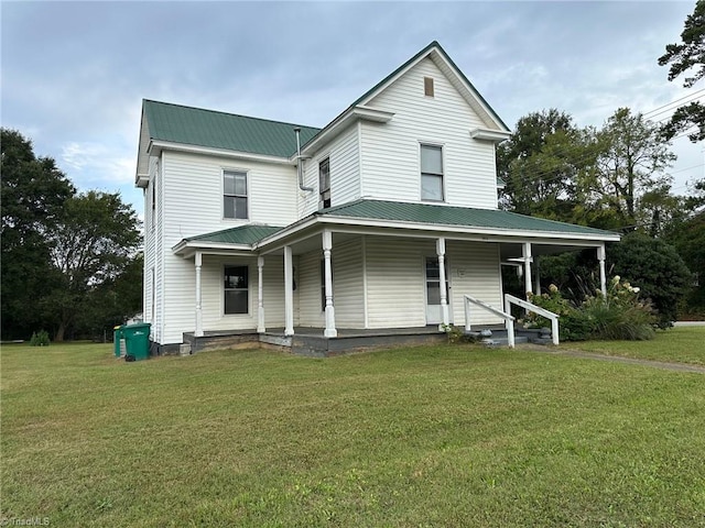 farmhouse-style home with a front lawn and covered porch