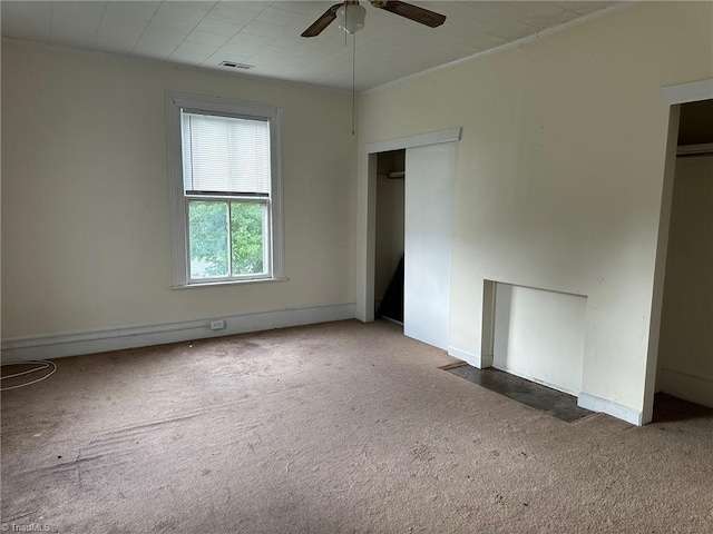 unfurnished room with ceiling fan and dark carpet