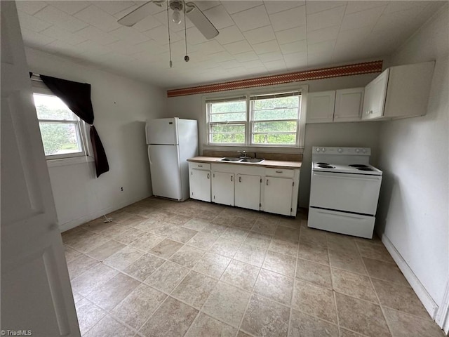 kitchen featuring a healthy amount of sunlight, white appliances, white cabinetry, and sink