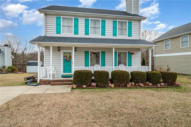 view of front property featuring a porch, a storage unit, and a front lawn