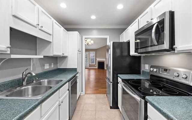 kitchen with white cabinets, sink, ornamental molding, and stainless steel appliances