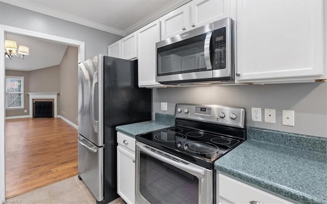 kitchen with light tile patterned floors, stainless steel appliances, white cabinets, and crown molding