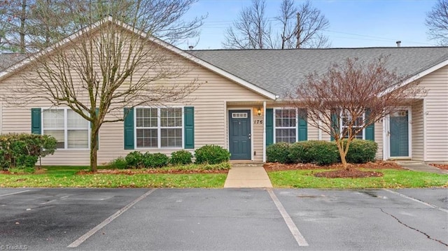 view of front of house featuring uncovered parking and a shingled roof