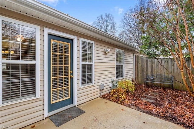 entrance to property with a patio and fence