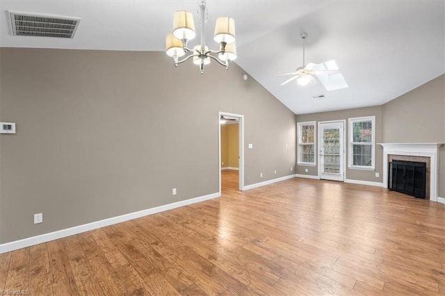 unfurnished living room featuring a fireplace, high vaulted ceiling, ceiling fan with notable chandelier, and hardwood / wood-style flooring