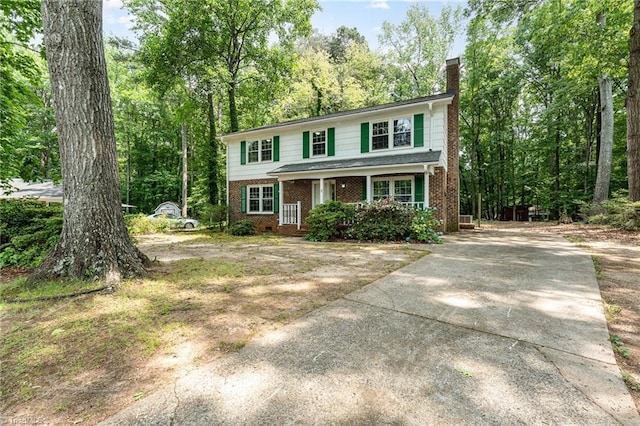 1 Red Fern Ct, Greensboro, NC 27455 - view of front of house featuring a porch, brick siding, a chimney, and concrete driveway
