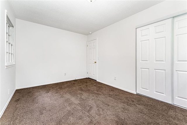 1 Red Fern Ct, Greensboro, NC 27455 - unfurnished bedroom featuring dark colored carpet, baseboards, and a closet