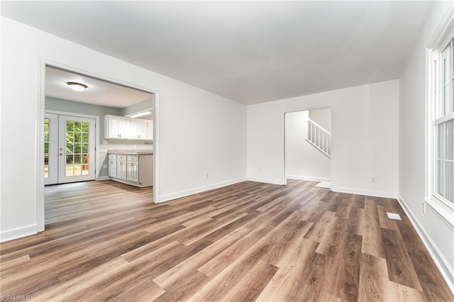 1 Red Fern Ct, Greensboro, NC 27455 - unfurnished living room with wood finished floors, baseboards, and stairway