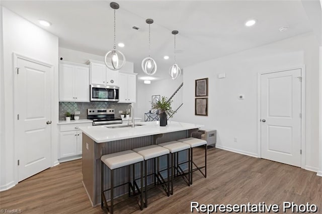6926 Baler Way Unit 19, Thomasville, NC 27360 - kitchen with stainless steel appliances, a kitchen bar, dark wood finished floors, decorative backsplash, and white cabinetry