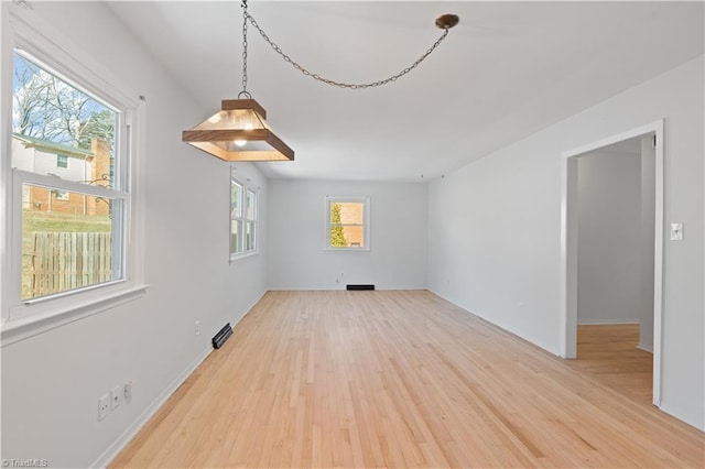 spare room featuring plenty of natural light and hardwood / wood-style flooring