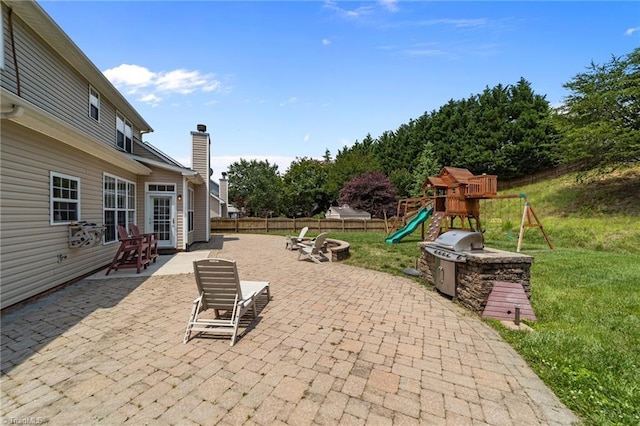 6416 Rock Springs Rd, Greensboro, NC 27410 - fenced backyard featuring an outdoor fire pit, area for grilling, a patio, and a playground