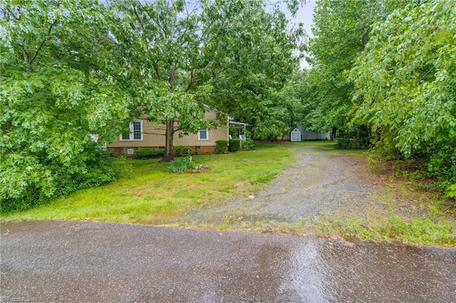 2796 Grant Trl, Randleman, NC 27317 - view of grassy yard with driveway, a storage shed, and an outbuilding