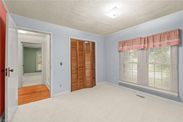 2796 Grant Trl, Randleman, NC 27317 - unfurnished bedroom with crown molding, a textured ceiling, carpet flooring, a closet, and baseboards