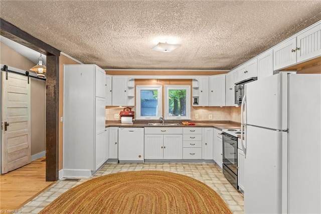 2796 Grant Trl, Randleman, NC 27317 - kitchen with white appliances, a barn door, open shelves, a sink, and white cabinets