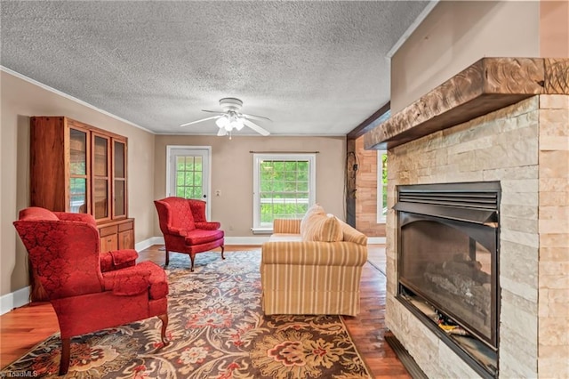 2796 Grant Trl, Randleman, NC 27317 - living area with wood finished floors, a glass covered fireplace, a textured ceiling, ceiling fan, and baseboards