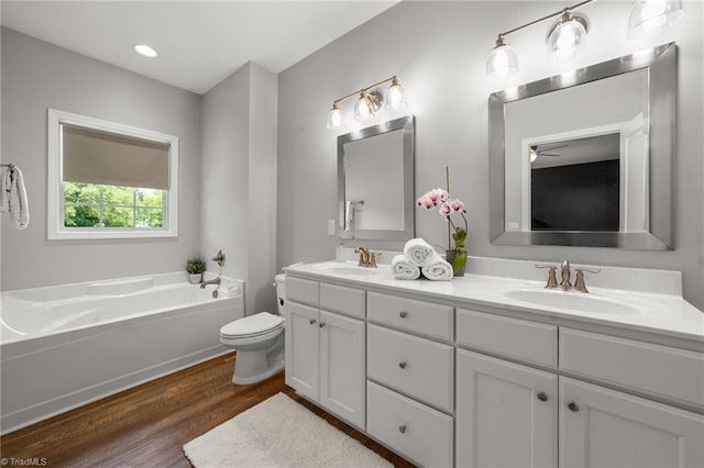 4215 Chippenham Ct, Graham, NC 27253 - full bathroom featuring double vanity, wood finished floors, toilet, a garden tub, and a ceiling fan