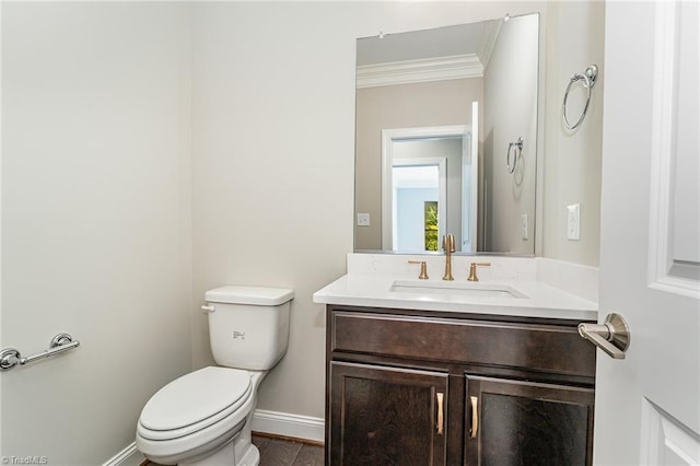 half bath with baseboards, crown molding, vanity, and toilet