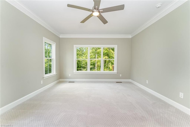 unfurnished room with visible vents, baseboards, ornamental molding, and light colored carpet