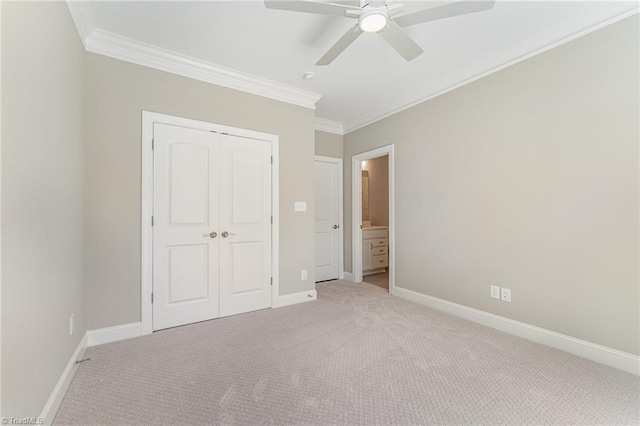 unfurnished bedroom with a closet, light carpet, crown molding, and baseboards