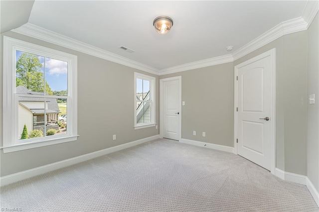 unfurnished room with baseboards, visible vents, ornamental molding, and light colored carpet