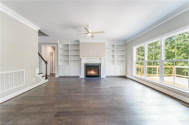 unfurnished living room with ornamental molding, built in features, ceiling fan, and dark hardwood / wood-style floors