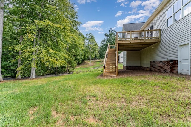 view of yard with a deck, an attached carport, and stairway