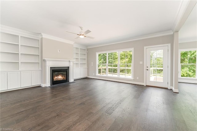 unfurnished living room featuring ceiling fan, dark wood-type flooring, a fireplace with flush hearth, baseboards, and crown molding