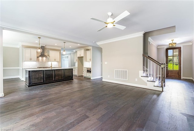 unfurnished living room with baseboards, stairs, and visible vents