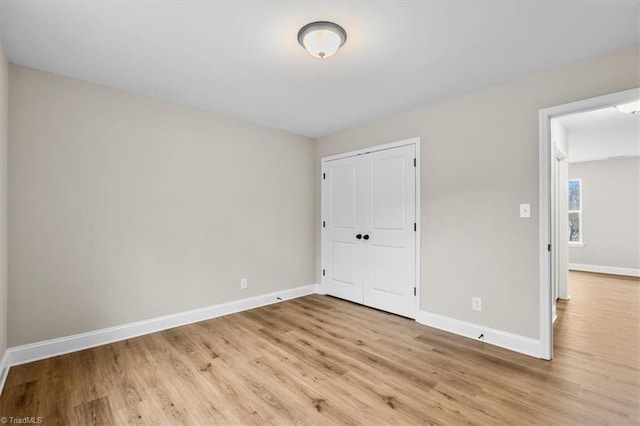 unfurnished bedroom with a closet and light hardwood / wood-style flooring