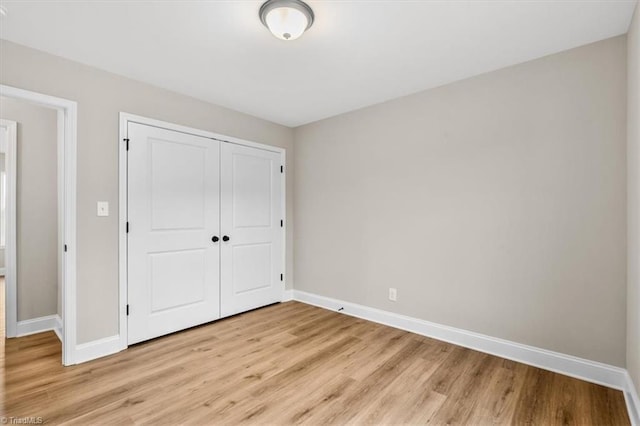 unfurnished bedroom featuring light hardwood / wood-style floors and a closet