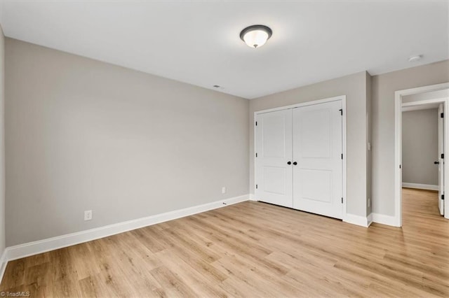 unfurnished bedroom with a closet and light wood-type flooring