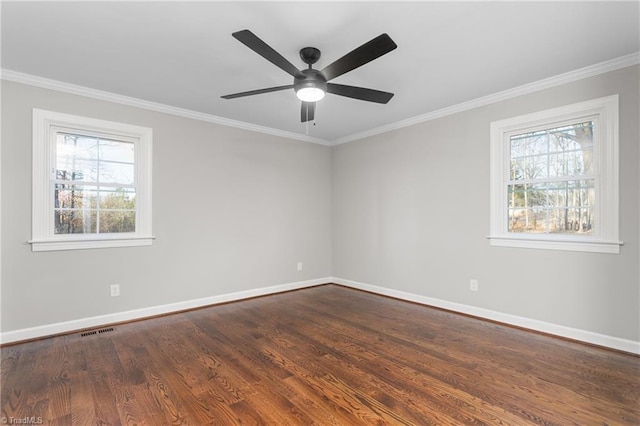 spare room with dark wood-style flooring, plenty of natural light, visible vents, and baseboards