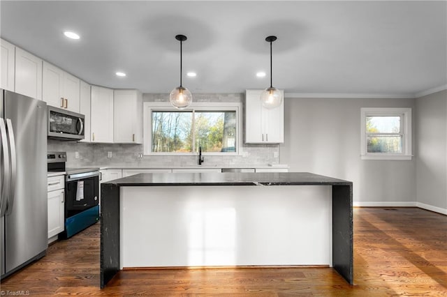 kitchen featuring a kitchen island, appliances with stainless steel finishes, white cabinets, and dark wood finished floors