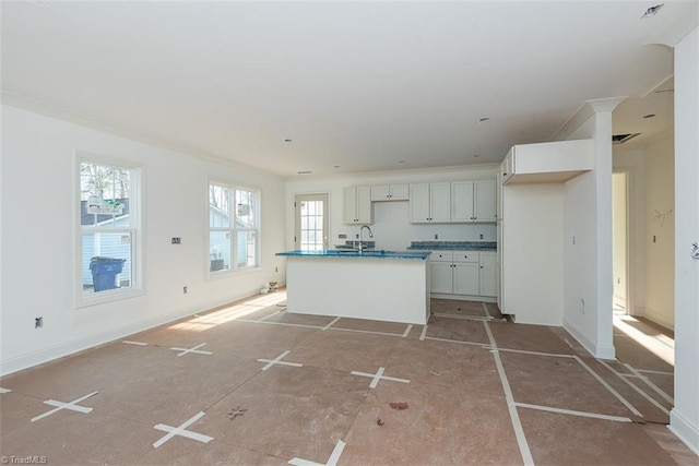 kitchen featuring white cabinetry, sink, and a kitchen island with sink