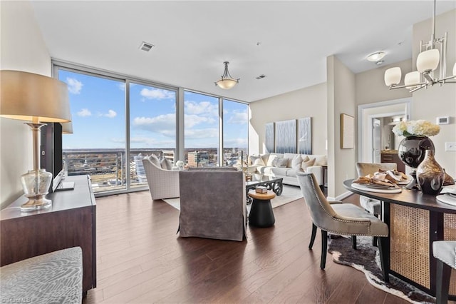 living room with floor to ceiling windows, dark hardwood / wood-style flooring, and an inviting chandelier