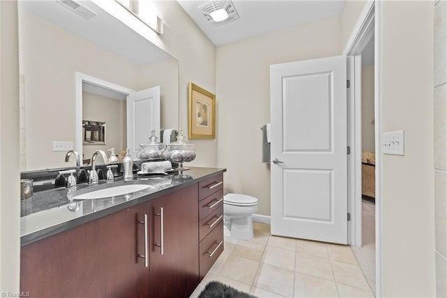 bathroom with tile patterned flooring, vanity, and toilet