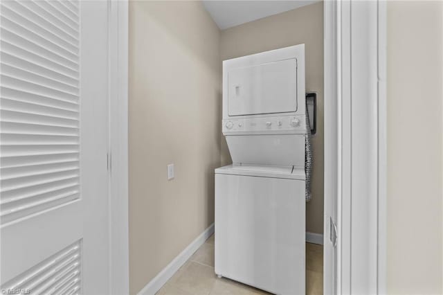 washroom featuring light tile patterned floors and stacked washer and clothes dryer