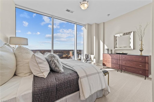 carpeted bedroom featuring a wall of windows