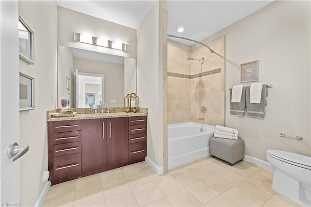 full bathroom with tile patterned floors, vanity, tiled shower / bath combo, and toilet