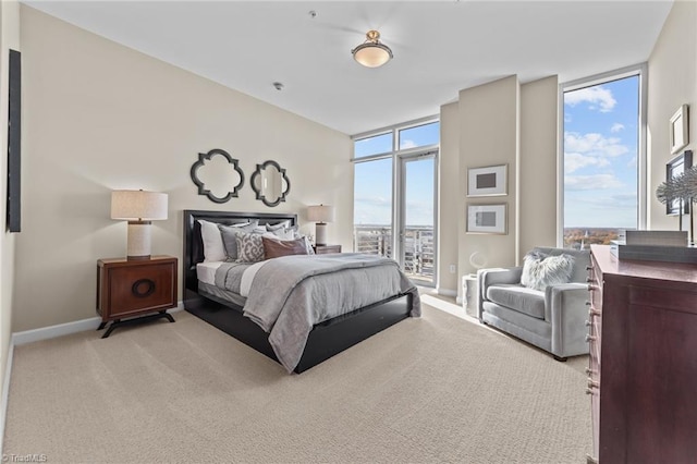 carpeted bedroom featuring access to exterior and a wall of windows