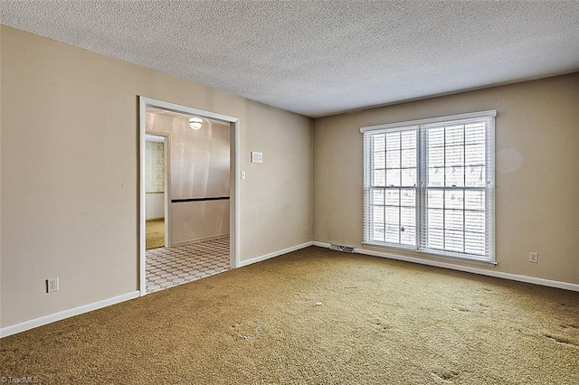 empty room with visible vents, baseboards, carpet, and a textured ceiling