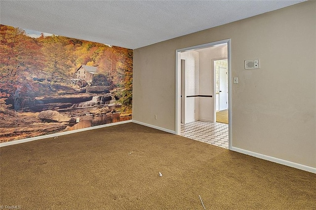 carpeted spare room with a textured ceiling and baseboards