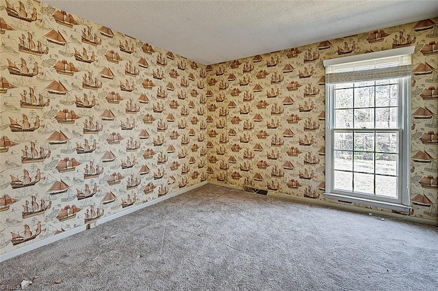 carpeted empty room with wallpapered walls, visible vents, baseboards, and a textured ceiling