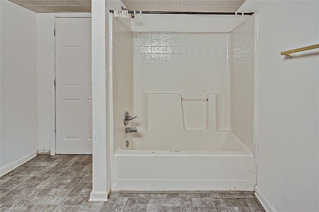 full bath with baseboards and shower / washtub combination