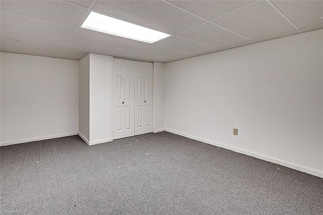 finished basement with a drop ceiling, baseboards, and carpet floors