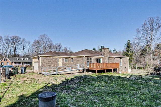 rear view of house featuring a wooden deck, a lawn, brick siding, and fence