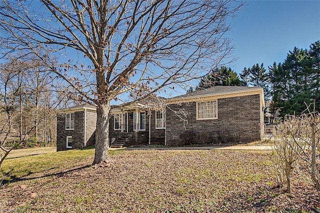 view of front facade with a front yard and brick siding