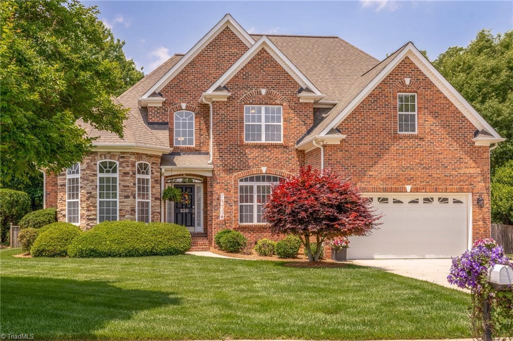 230 Lee Smith Ln, Kernersville, NC 27284 - traditional-style house featuring concrete driveway, brick siding, a front yard, and an attached garage